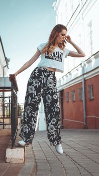 Fashion portrait stylish pretty woman in sunglasses posing in the city, street fashion. You look cool on white t-shirt