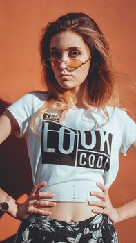 Fashion portrait stylish pretty woman in sunglasses posing in the city, street fashion. You look cool on white t-shirt