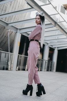 Beautiful cool girl with dreadlocks full length. Photo in the city - urban style