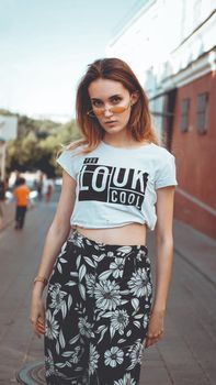 Fashion portrait stylish pretty woman in sunglasses posing in the city, street fashion. You look cool on white t-shirt