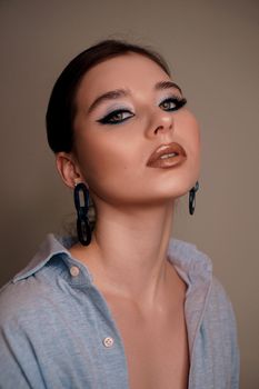 Beauty portrait with professional blue makeup. Fashion portrait of a beautiful brunette woman. Make-up artist, beauty salon, stylist, magazine