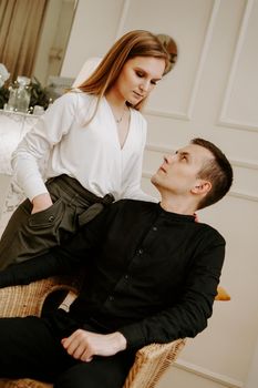 Loving couple at home. Pretty blonde in a white blouse. Couple in formal business attire