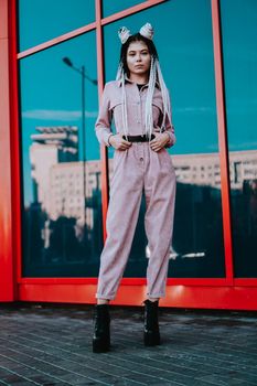 Beautiful cool girl with dreadlocks full length. Photo in the city - urban style