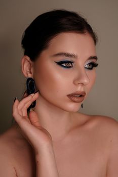 Beauty portrait with professional blue makeup. Fashion portrait of a beautiful brunette woman. Make-up artist, beauty salon, stylist, magazine