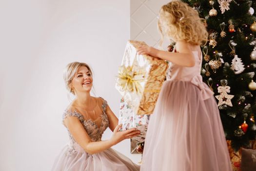 Christmas concept. Happy mother and little daughter in christmas room. Give gifts