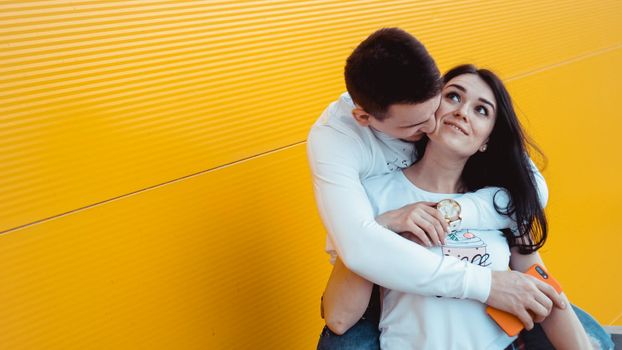 Image of Young lovely couple posing together and hugging over yellow background