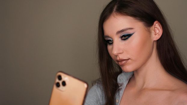 Young attractive model make a selfie after makeup in beauty studio.