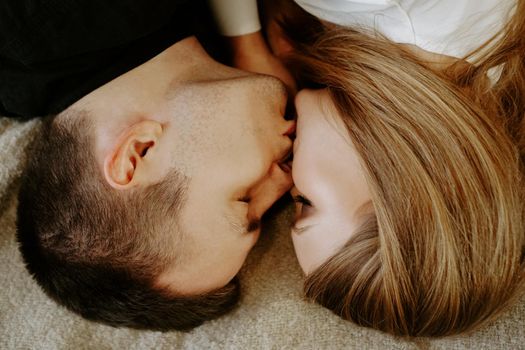 Close-up portrait of a young couple in bed at home - top view