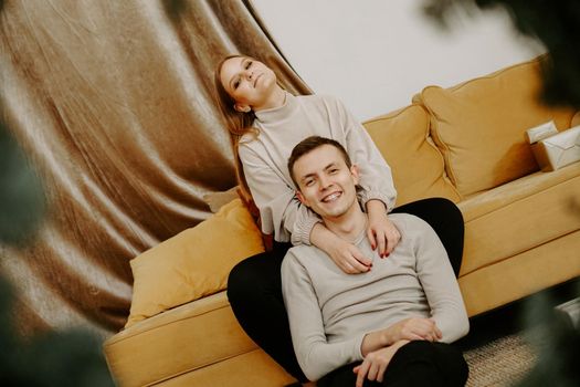 Couple relaxing together on the couch. Happy young couple having fun on the sofa. Beautiful young couple is hugging and smiling