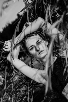 Woman in bikini on a tropical beach with plants - summer time. Black and white