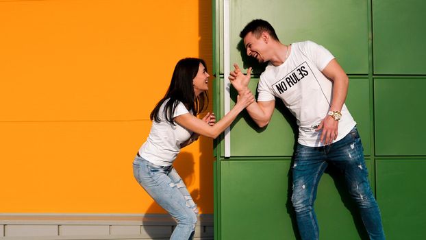 Young couple in love hiding from each other. The girl scared the guy, jumping out from around the corner. The couple is happy and laughing