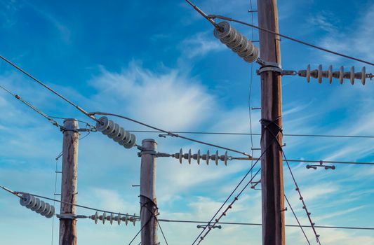 Photograph of a wooden telephone post and cables against a blue sky