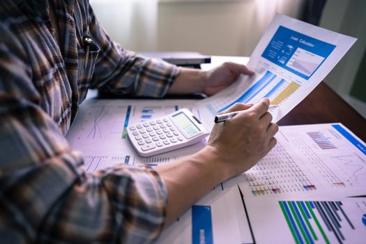 Bookkeeper examine Company performance on table with profit document, earnings, income and loss. Finance and Accounting concept.