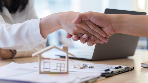 Woman real estate agents or house seller and customers shake hand, After discussing about buying a house successfully. Concept of loan, buying, mortgage for living housing.