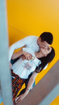 Image of Young lovely couple posing together and hugging over yellow background