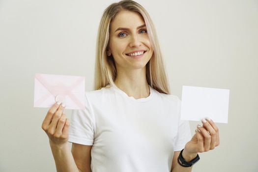 Woman in white t-shirt hold white blank paper sheet in hand - mockup
