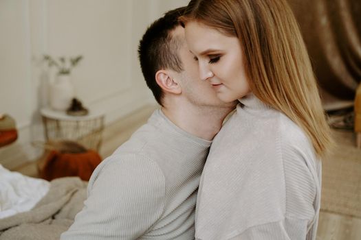 Pretty loving couple is luxuriating in bed together. They are hugging and smiling