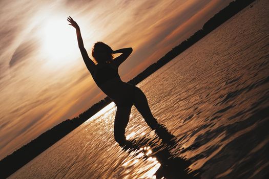 Happy Carefree Woman Enjoying Beautiful Sunset on the Beach - Summer photo