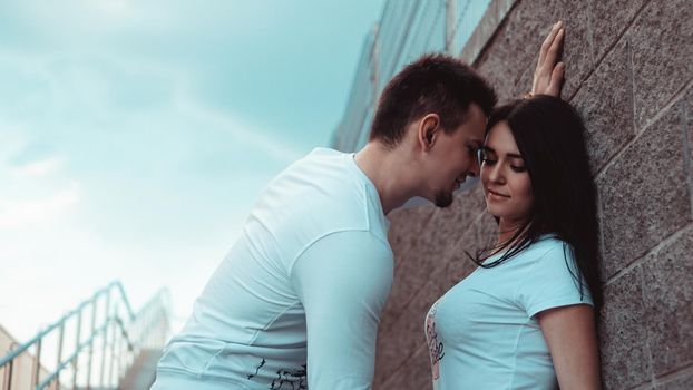 Young loving couples standing next to the brick wall, happy and satisfied, lifestyle concept