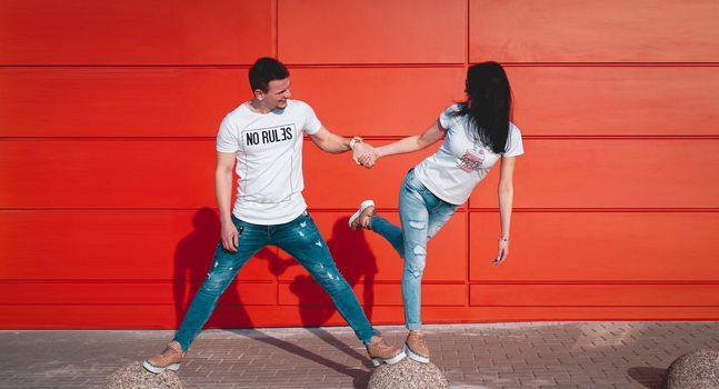 Young smiling couple in love man holding attractive woman hand, spending time together, enjoying - red background