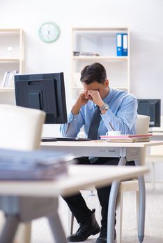 Handsome businessman employee sitting at his desk in office