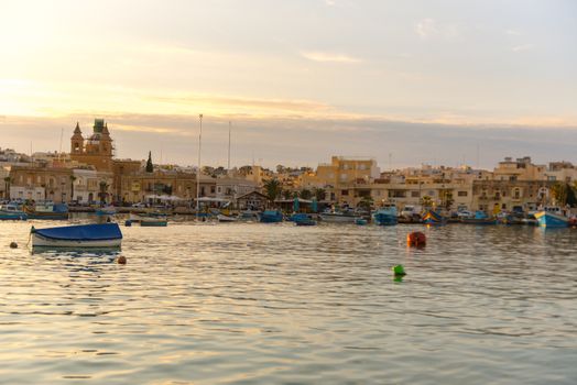 Traditional eyed colorful boats Luzzu in the Harbor of Mediterranean fishing village Marsaxlokk, Malta