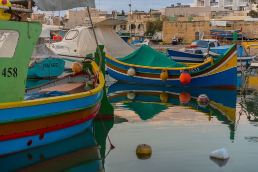 Traditional eyed colorful boats Luzzu in the Harbor of Mediterranean fishing village Marsaxlokk, Malta