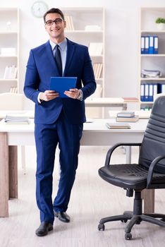 Young handsome businessman employee working in office at desk