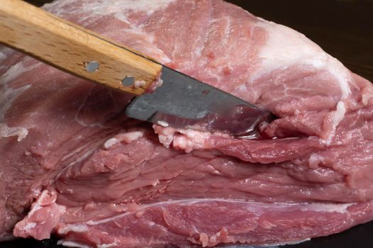 Slice the pork or beef with a knife on the table in close-up.Preparation of meat dishes and food products.Pieces of red meat for shish kebab,barbecue or kebab.Raw fresh meat is cut with a knife.recipe