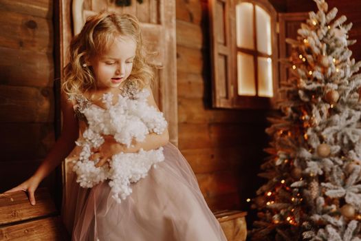 Little girl in pink dress is holding fake snow - christmas time