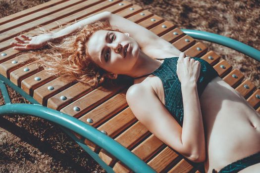 Portrait of beautiful young woman in the swimsuit relaxing on the beach - fashion portrait