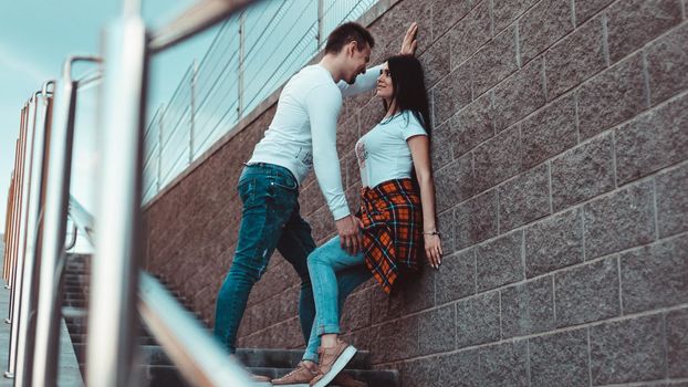 Young loving couples standing next to the brick wall, happy and satisfied, lifestyle concept