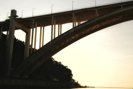 Beautiful and colossal Arrabida bridge over the waters of the Douro River in Porto at sunset