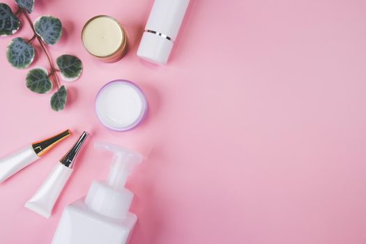 Mockup cosmetic bottle with cream or lotion and leaf isolated on pink background, mock up package for advertising, skincare or cosmetology, top view, flat lay, skin care and treatment with product.