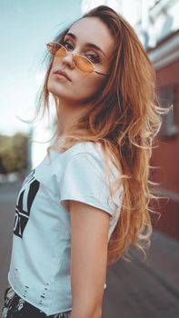 Fashion portrait stylish pretty woman in sunglasses posing in the city, street fashion