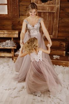 Happy Mother and daughter dancing in front of a Christmas decoration