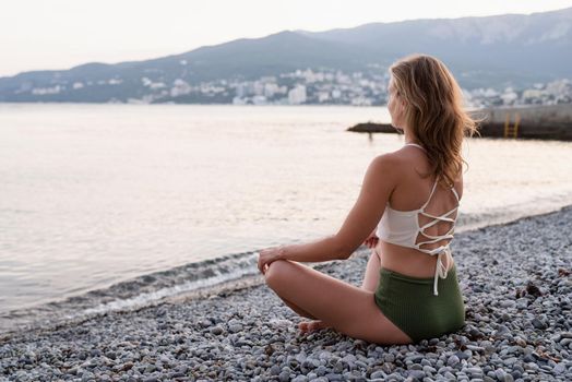 Vacation. Health concept. beautiful young woman in swimsuit meditating on the beach