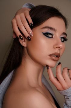 Beauty portrait with professional blue makeup. Fashion portrait of a beautiful brunette woman. Make-up artist, beauty salon, stylist, magazine