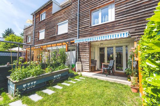 Cozy little green garden with raised bed and veranda, summer time