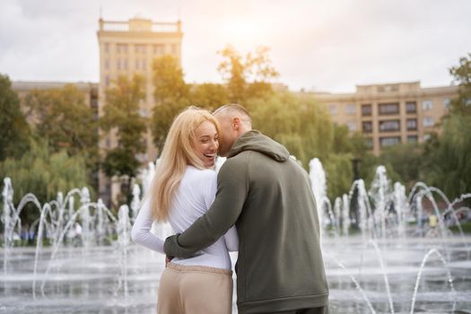 Couple in love walking outdoors park fountain Caucasian man woman walk outside after jogging dressed sport clothes Healthy livestyle Rear view