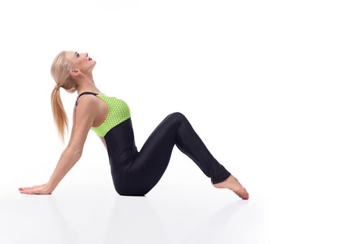 Fit women are the best. Horizontal studio shot of a beautiful blonde haired sportswoman relaxing sitting on the floor gracefully copyspace isolated