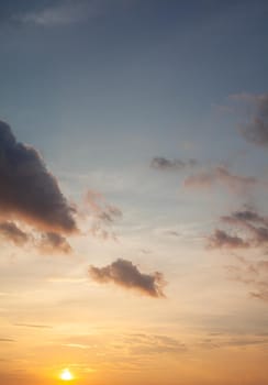 Colorful sunset or sunrise in the sky. The sky and clouds are painted in different bright orange, yellow and blue colors.