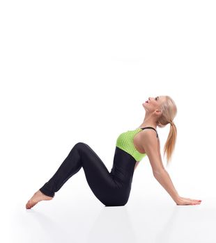 Looking and feeling great. Studio portrait of a beautiful blonde female with perfectly shaped body sitting on the floor leaning on her arms gracefully isolated copyspace