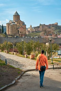 The guy walks up the hill to the Old Georgian-style church. Metekhi monastery in Tbilisi.