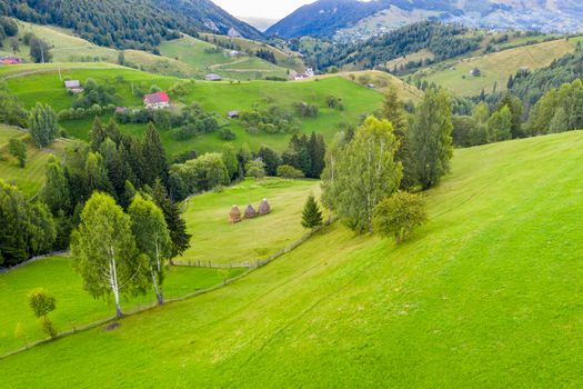 Beautiful aerial landscape from a traditional mountain village from Romanian Carpathians, Bran valley summer scene in Transylvania