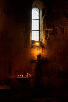 Dark temple with small windows and burning candles.