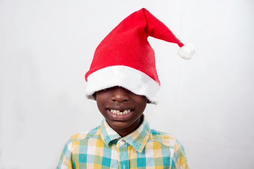 portrait of little happy boy wearing a Santa Claus hat isolated on white background.