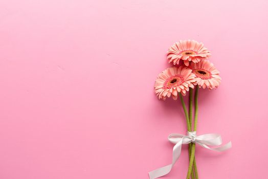 Pink gerbera daisies bouquet with ribbon. Minimal design flat lay. Pastel colors. Happy birthday