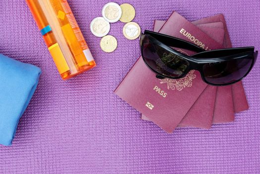 Top view of summer travel accessories on purple background