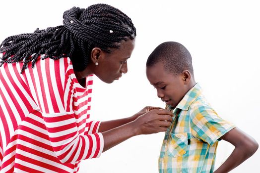 young woman dressing her child by wearing his shirt.
